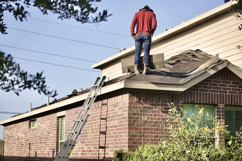 Professional roofer working on a residential roof in Kendall West